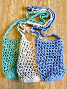 three crocheted bags sitting on top of a wooden table