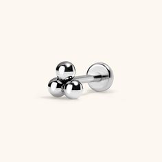 two balls are attached to the end of a pair of silver ear studs on a white background