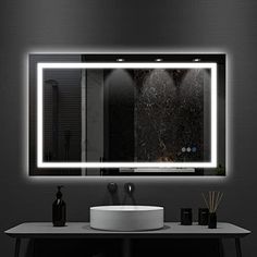 a bathroom with a sink, mirror and lights on the wall above it's counter