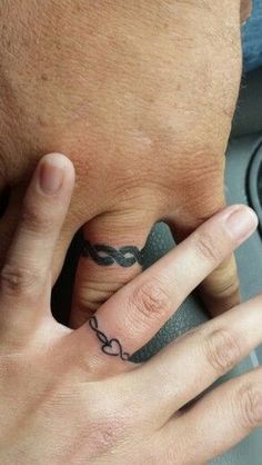 a man's hand with a ring tattoo on it