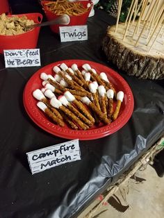 a red plate topped with marshmallows on top of a black cloth covered table