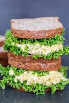 three sandwiches stacked on top of each other with cheese and lettuce in them