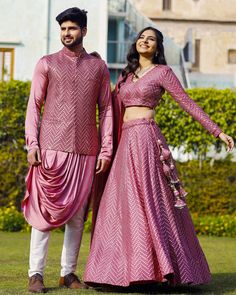 Menswear:- Satin Cowl Style Kurta in Pink.This Readymade attire with Satin Lining is Enhanced with Pockets, Mirror Effect and Resham Work. Crafted in Chinese Collar Neck and Full Sleeve Available with a Cotton Aligarhi Pant in White and a Faux Georgette Nehru Jacket in Pink Lehenga Choli:- Readymade Faux Georgette Lehenga in Pink This attire with Shantoon and Cotton Lining is Enhanced with Fancy Tassels, Side Zip, Resham and Mirror Work. Available with a Faux Georgette Pink Choli Crafted in V Ne Mirror Work Couple Outfit, Formal Festive Set With Unstitched Blouse, Party Wear Sets With Cutdana For Eid, Eid Party Wear Sets With Cutdana, Bollywood Style Formal Sets With Gota Work, Formal Unstitched Blouse Sets For Navratri, Formal Sets With Unstitched Blouse For Navratri, Festive Party Wear Sets With Traditional Drape, Festive Cutdana Party Sets