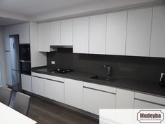 an empty kitchen with white cabinets and black counter tops is seen in this image from across the room