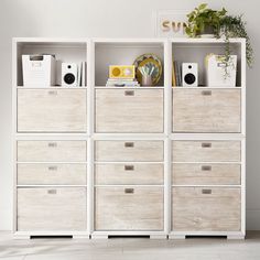 a white bookcase filled with lots of drawers