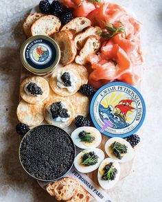 an assortment of crackers, cheeses and blackberries are arranged on a platter