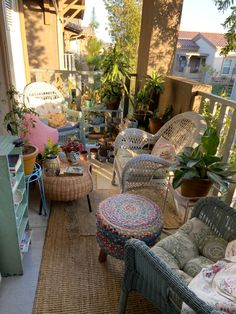 an outdoor patio with wicker furniture and potted plants on the balcony area,