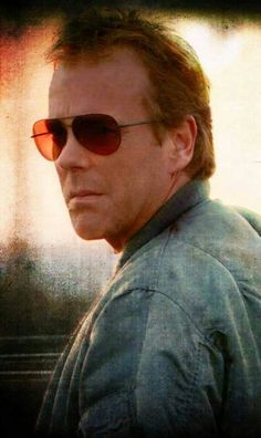 a man wearing sunglasses and looking off into the distance