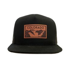 Colorado Elevation mountains faux leather patch in rawhide. Available in silver gray or black. Flat bill cotton twill front. Mesh back with adjustable snapback Urban Trucker Hat With Logo Patch For Outdoor, Black Leather Hats For Outdoor Activities, Urban Trucker Hat With Logo Patch, Urban Trucker Hat With Logo Patch And Flat Bill, Urban Trucker Hat With Flat Bill And Logo Patch, Urban Adjustable Trucker Hat With Logo Patch, Flat Bill Hat With Logo Patch For Outdoor Activities, Outdoor 5-panel Baseball Cap With Leather Patch, Brown Flat Bill Snapback Hat For Camping