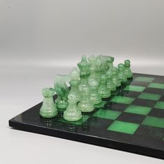 a chess board with green glass pieces on it