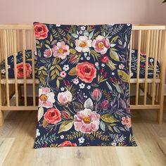 a baby crib with a floral blanket on it