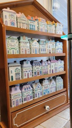 a wooden shelf filled with lots of little houses on top of it's sides