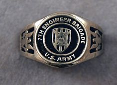 This pewter ring shows the 7th Engineer Brigade insignia of the US Army.  The pewter ring has a silver color and has been blackened in the backgrounds of the main design and band to provide contrast. All of our rings are made in the USA from Pewter that is free of Lead and Nickel The top design part of the ring measures about 15 mm in diameter. The ring band tapers from about 15mm to about 4.5mm at the bottom and is about 1.75mm thick. We offer free shipping within the USA. Rings are available in sizes 7 to 14.  If you cannot find your unit send me a message it may be available but not yet listed as I have over 400 different unit rings. Pewter Ring, Army Corps Of Engineers, Top Design, Ring Band, Us Army, Rings Statement, Silver Color, Band Rings, Statement Rings