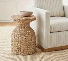 a wicker table sitting on top of a rug next to a chair