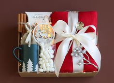 a gift box filled with coffee, marshmallows, cinnamon sticks and other items