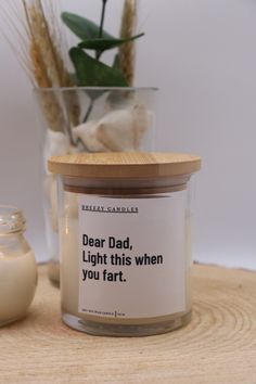 a glass jar with a candle next to it