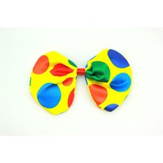 a yellow and blue polka dot hair bow on a white background with green, red, orange, and blue dots