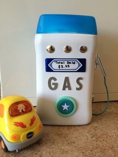 a toy car next to an old fashioned gas pump