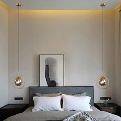 a bed with two lamps hanging above it