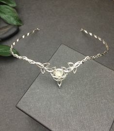 I've fabricated a Celtic inspired wedding bridal circlet, entirely in sterling silver, featuring 5 Trinity Knots with an 8mm round White Moonstone. If you wish a different gemstone, then please select from the gemstone list within the listing! This piece is lovely, hand-fabricated by me only and the circlet can be used for a wedding accessory, or any costuming event. Please allow me 5-7 business days to fabricate a new headpiece! **For matching earrings: https://www.etsy.com/listing/42139307/ste Delicate Silver Bridal Necklace, Delicate Silver Halo Jewelry, Adjustable Silver Jewelry With Halo Detail, Hand Forged White Jewelry For Wedding, Elegant Silver Headpieces For Gifts, Silver Teardrop Crown Jewelry For Anniversary, Handmade Silver Crown-shaped Jewelry, Silver Hand Forged Jewelry For Wedding, Handmade Silver Crown Jewelry