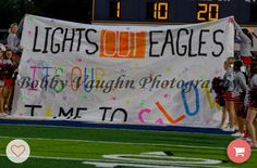 some cheerleaders are standing in front of a sign that says lights out eagles