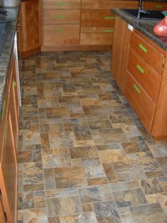 a kitchen with wooden cabinets and tile flooring