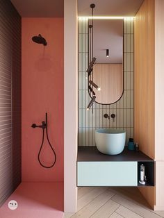 a bathroom with pink walls and a white bowl on the counter in front of it