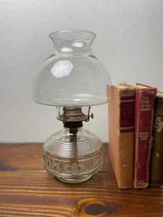 a glass vase sitting on top of a wooden table next to two bookends