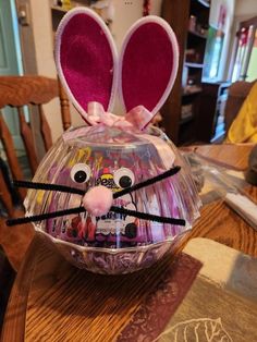 a plastic easter egg with ears and eyes sitting on top of a dining room table