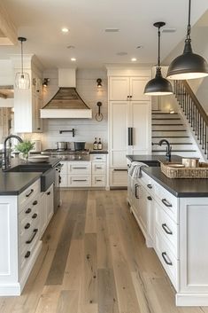 a large kitchen with white cabinets and black counter tops, along with an island in the middle