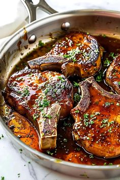 a pan filled with meat covered in sauce and garnished with parsley