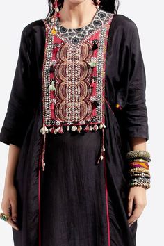 Black kurta with embroidered yoke, featuring resham thread embroidery with sequins, cowry shells and tassel embellishments and contrast seam inserts. Paired with printed narrow trouser.
Component: 2
Embroidered, Printed
Neckline: Round
Sleeve Length: Three Quarter
Fabric: Kurta: Cotton Silk; Trouser: Cotton 
Color: Black, Red
Side gathering panel
Back keyhole closure
Back elasticated trouser
Note: The stole and top worn by the model is for styling purpose only - Aza Fashions Intricate Embroidered Top For Navratri, Intricately Embroidered Festive Top For Navratri, Embellished Chanderi Kurta For Festivals, Anarkali Embroidered Top For Navratri With Intricate Embroidery, Festivals Embellished Chanderi Kurta, Embellished Chanderi Traditional Wear For Navratri, Bohemian Chanderi Sets With Intricate Embroidery, Embellished Multicolor Kurta For Eid, Embellished Kurta For Navratri Festival