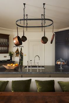 a kitchen island with pots and pans hanging from it