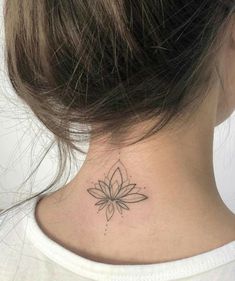 a woman's neck with a small flower tattoo on the back of her neck