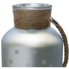 a large metal vase with rope wrapped around it's top and bottom, decorated with snowflakes