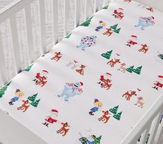 a white crib with christmas themed sheeting on the top and bottom part of it