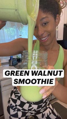 a woman pouring green walnut smoothie into a jar with the words green walnut smoothie on it