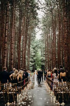 the aisle is lined with candles and people are walking down it