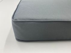 a close up view of a gray cushion on a white counter top with no one around it