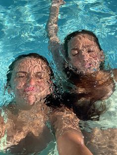 two people in the water with their hands up