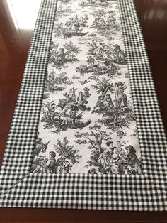 a black and white table runner on top of a wooden table