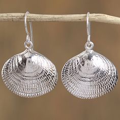 Gleaming with intricate patterns two sterling silver seashells form this pair of dangle earrings from Mexico. Oscar Figueroa Escorcia designs the earrings which carry on the tradition of Taxco silversmithing. Silver Ocean-inspired Earrings, Nickel-free Silver Ocean-inspired Earrings, Sterling Silver Shell Earrings For Gift, Ocean-inspired Sterling Silver Drop Earrings, Silver Ocean-inspired Earrings For Gifts, Silver Nickel-free Shell-shaped Earrings, Silver Shell-shaped Earrings, Sterling Silver Ocean-inspired Earrings With Ear Wire, Silver Shell-shaped Earrings With Ear Wire