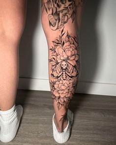 a woman's legs with tattoos and flowers on them