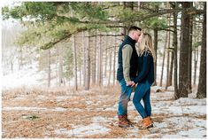 a man and woman are standing in the snow by some trees with their backs to each other