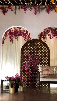 a living room with flowers on the wall and couches in front of an archway