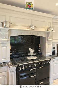 an old fashioned black and white stove in the middle of a kitchen with marble counter tops