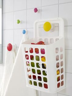 a white laundry basket hanging on the wall