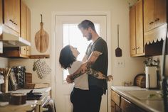 a man standing next to a woman in a kitchen