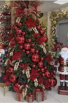 a christmas tree decorated with red and gold ornaments in a room filled with other holiday decorations