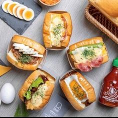 there are many different types of sandwiches on the table with eggs and condiments